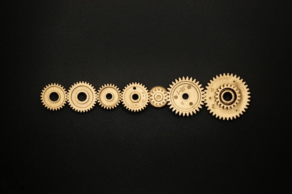 An artistic arrangement of golden gears on a dark backdrop, symbolizing mechanics and cooperation.